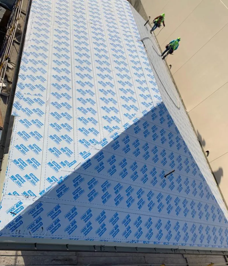 Professional roofers installing underlayment on a metal roof in Portland